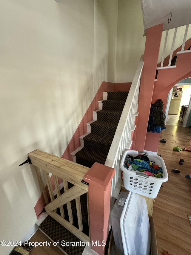 staircase with hardwood / wood-style floors