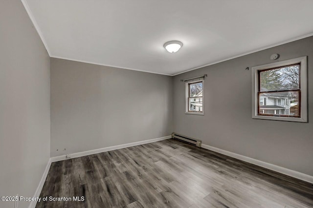 unfurnished room with baseboards, baseboard heating, crown molding, and wood finished floors