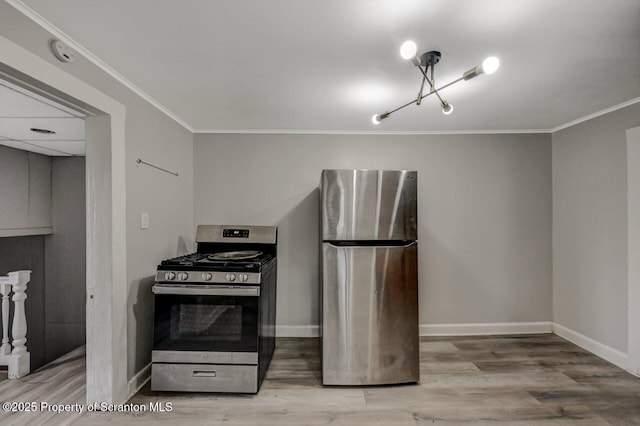 kitchen with appliances with stainless steel finishes, ornamental molding, baseboards, and wood finished floors