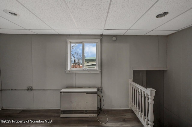 basement with a drop ceiling and wood finished floors