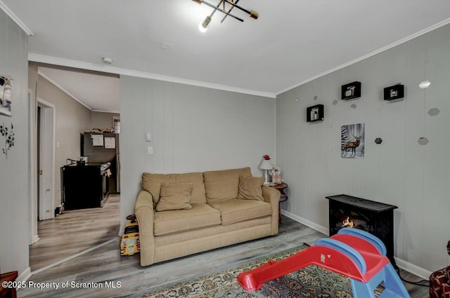 living room featuring ornamental molding, wood finished floors, and baseboards