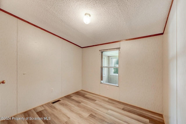 empty room with hardwood / wood-style flooring and a textured ceiling