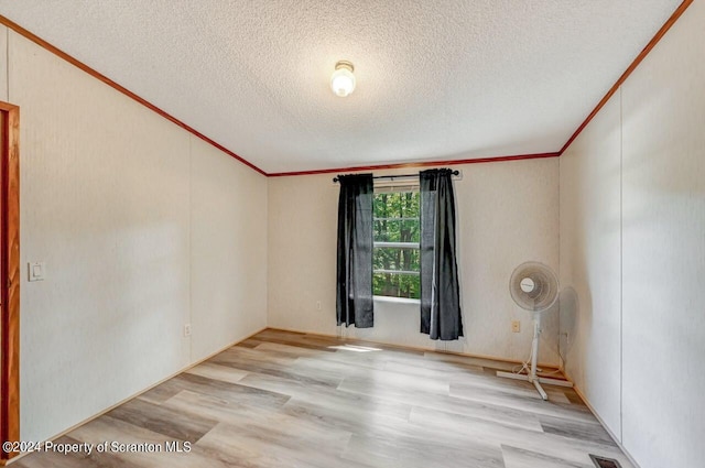 unfurnished room featuring a textured ceiling and light hardwood / wood-style floors