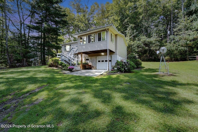 rear view of house featuring a yard and a garage