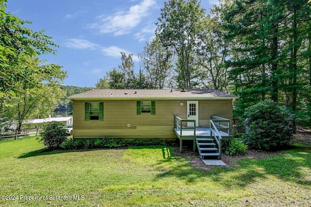 rear view of house with a yard and a deck