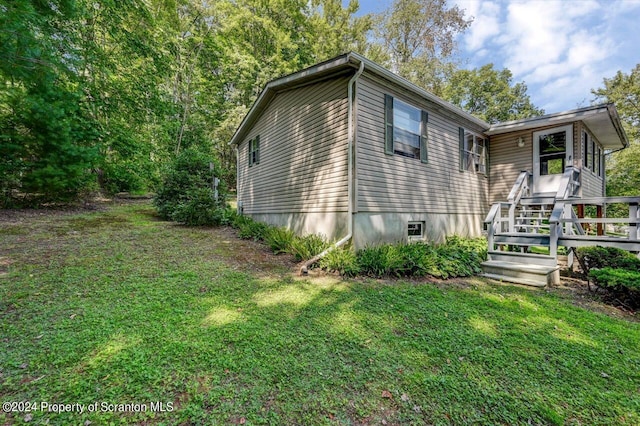 view of side of home with a lawn