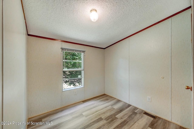 empty room featuring light hardwood / wood-style flooring and a textured ceiling