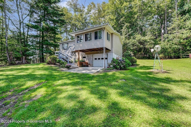 back of property with a garage and a yard