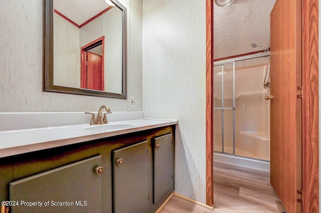 bathroom with hardwood / wood-style floors, vanity, and an enclosed shower