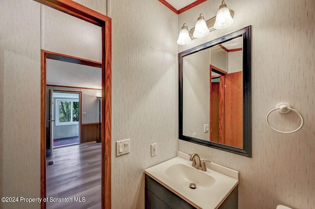 bathroom featuring hardwood / wood-style flooring, vanity, and ornamental molding