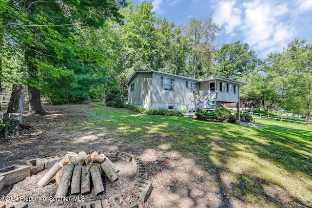 exterior space featuring a yard, a fire pit, and a wooden deck