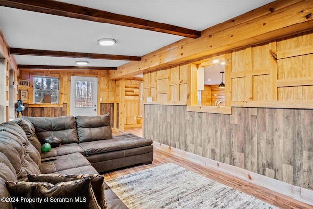 living room with hardwood / wood-style flooring, beam ceiling, and wooden walls