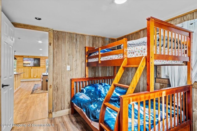 bedroom featuring hardwood / wood-style flooring and wood walls