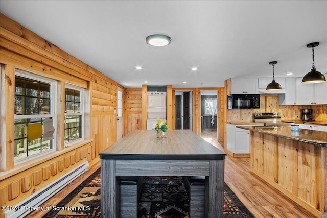 kitchen featuring a center island, white cabinets, hanging light fixtures, dark stone countertops, and a baseboard radiator