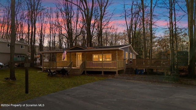 view of front of house featuring a lawn and a deck