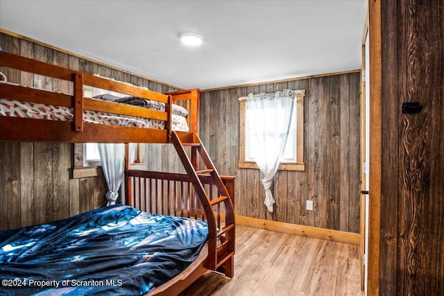 bedroom featuring hardwood / wood-style flooring and wood walls