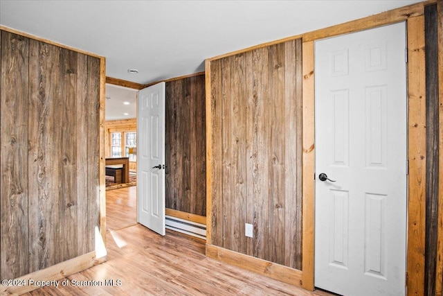 unfurnished bedroom featuring light wood-type flooring and wooden walls