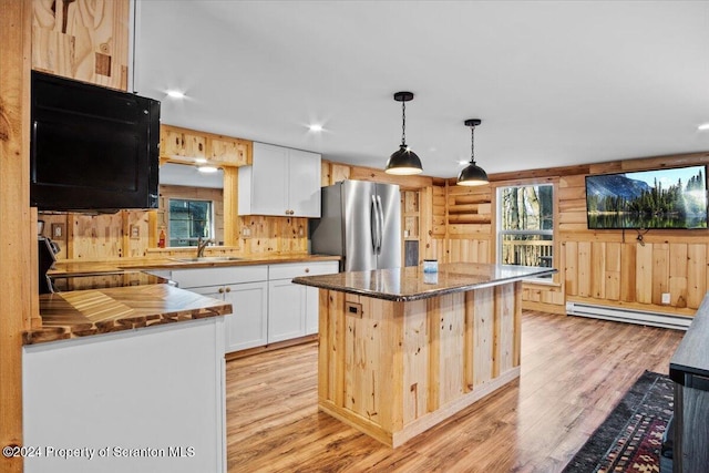 kitchen featuring white cabinets, stainless steel fridge, a kitchen island, and a baseboard radiator