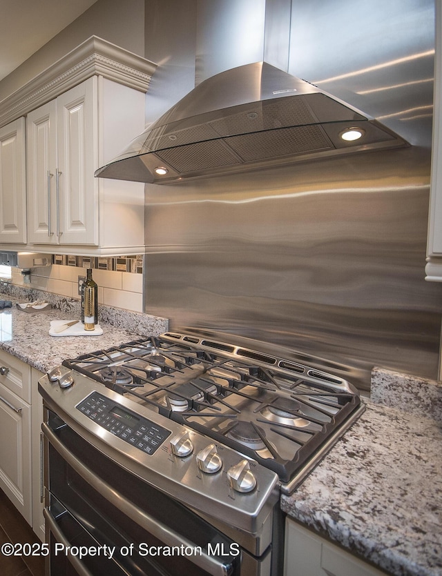 224 Shadow Wood Cir, Archbald, PA 18403 - kitchen featuring island exhaust hood, light stone counters, white cabinetry, backsplash, and stainless steel gas stove