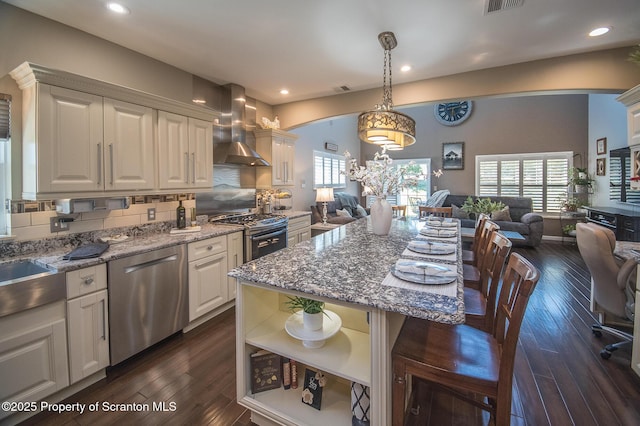 224 Shadow Wood Cir, Archbald, PA 18403 - kitchen featuring dark wood-style flooring, open floor plan, open shelves, wall chimney exhaust hood, and stainless steel appliances