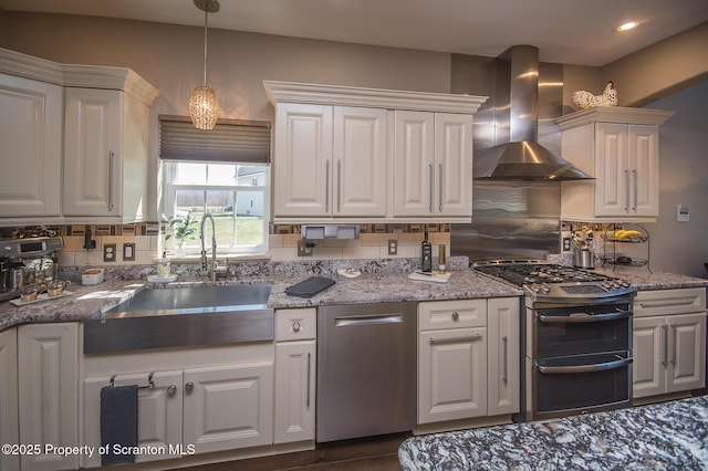 224 Shadow Wood Cir, Archbald, PA 18403 - kitchen featuring tasteful backsplash, white cabinets, wall chimney exhaust hood, a sink, and appliances with stainless steel finishes