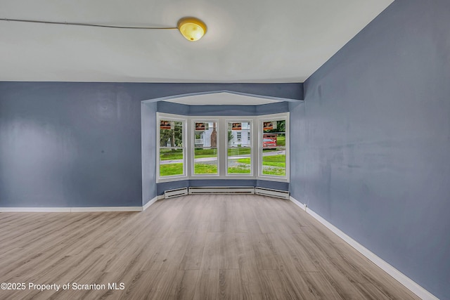 336 Grand Ave, Clarks Summit, PA 18411 - spare room featuring wood finished floors, arched walkways, and a baseboard heating unit