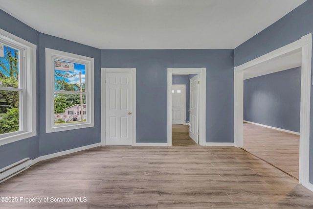 336 Grand Ave, Clarks Summit, PA 18411 - unfurnished bedroom featuring a baseboard radiator and wood finished floors