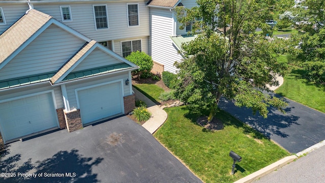 2103 Robinson Close, Moosic, PA 18507 - view of front of house with asphalt driveway, a garage, brick siding, a standing seam roof, and a front lawn