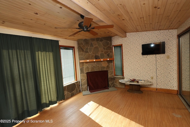 unfurnished living room featuring beam ceiling, wood finished floors, wooden ceiling, and ceiling fan