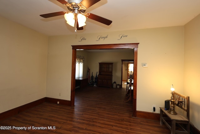 empty room with wood finished floors, baseboards, and ceiling fan