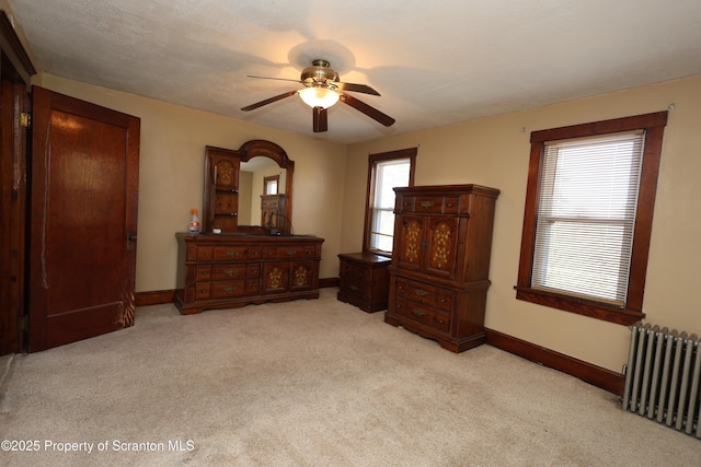 bedroom featuring baseboards, multiple windows, radiator, and carpet