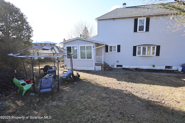 back of property featuring entry steps and a shingled roof