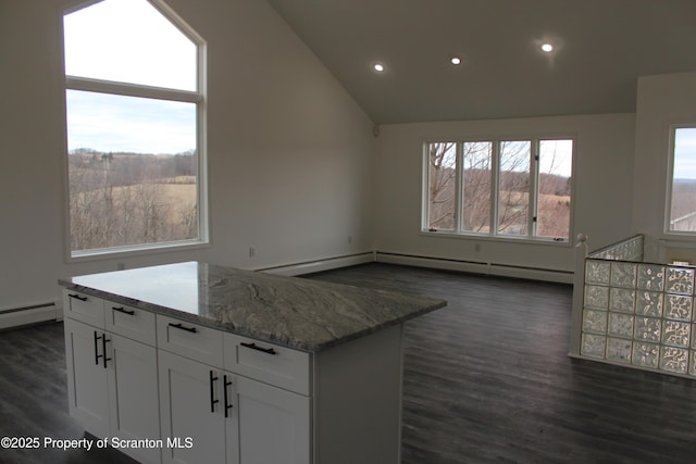 kitchen with dark wood finished floors, recessed lighting, white cabinets, lofted ceiling, and light stone countertops