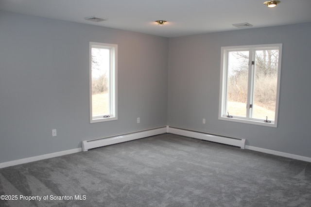 carpeted empty room with visible vents, a healthy amount of sunlight, and baseboards