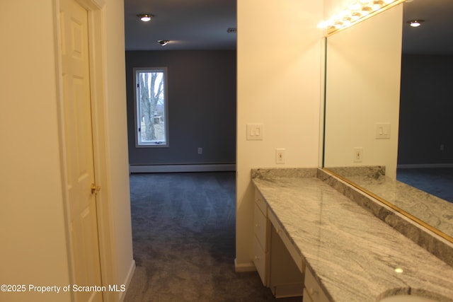 bathroom with vanity, baseboards, and a baseboard radiator