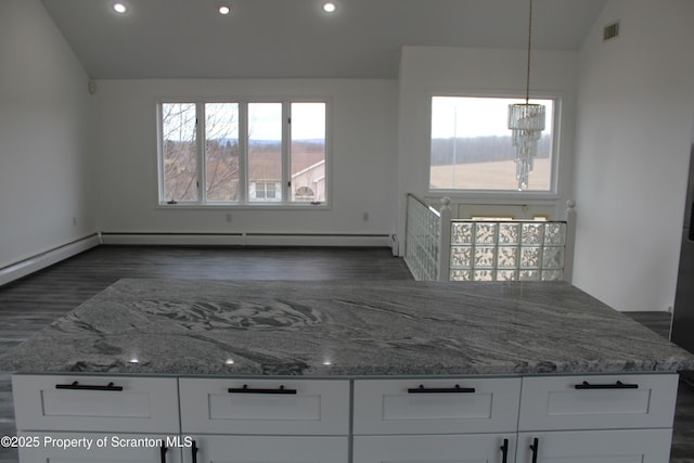 kitchen featuring visible vents, white cabinets, light stone countertops, a chandelier, and vaulted ceiling