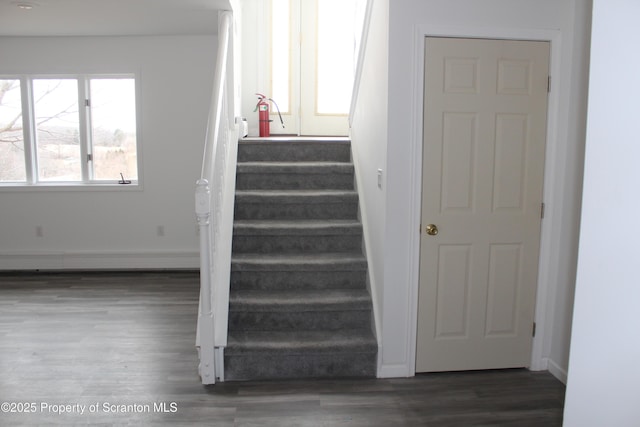 stairs featuring wood finished floors and baseboards