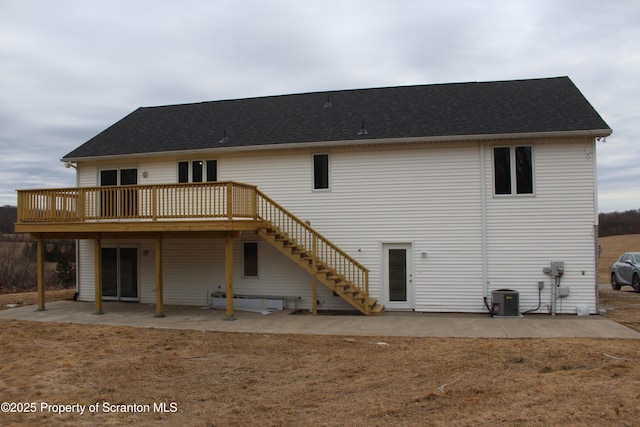 rear view of house featuring stairway, central air condition unit, a wooden deck, and a patio