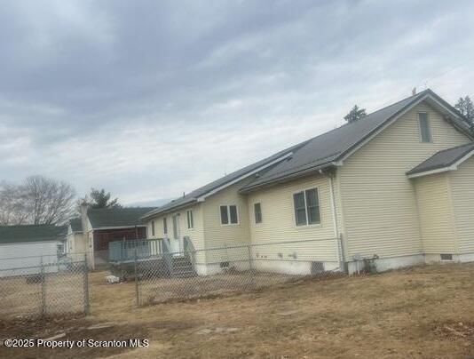 view of side of property featuring fence and crawl space