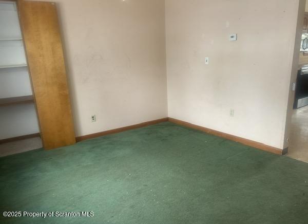 carpeted empty room featuring baseboards