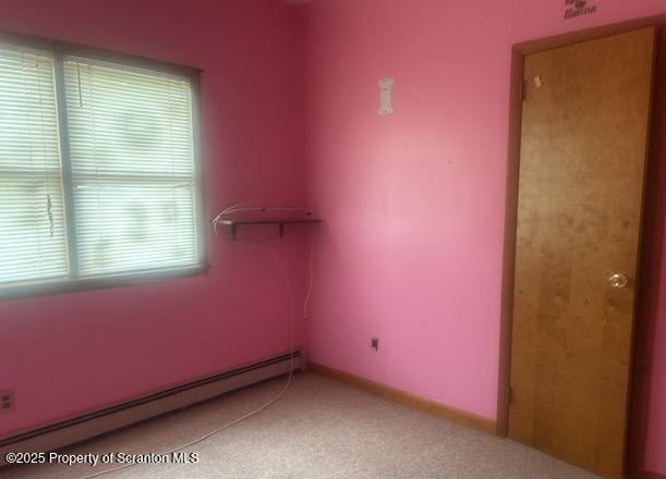 spare room featuring a baseboard radiator and baseboards