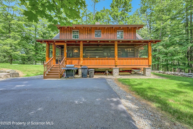 5 Capricorn Cir, Lake Ariel, PA 18436 - rustic home with a sunroom, a front yard, and board and batten siding