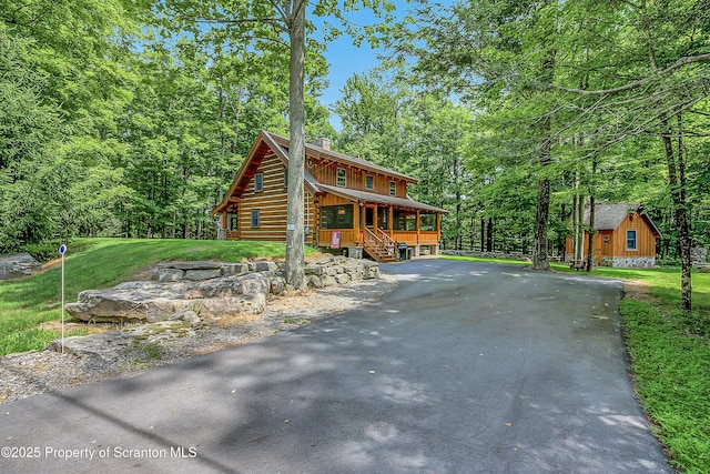 5 Capricorn Cir, Lake Ariel, PA 18436 - cabin featuring a porch, a chimney, an outdoor structure, driveway, and board and batten siding