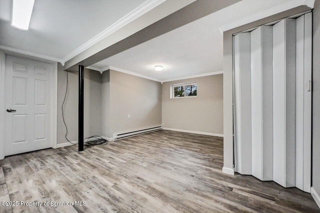 basement featuring baseboard heating, crown molding, and hardwood / wood-style floors