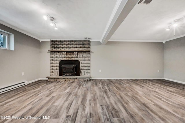 unfurnished living room with hardwood / wood-style flooring, ornamental molding, a fireplace, and a baseboard heating unit