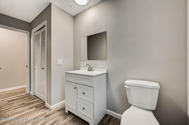 bathroom featuring hardwood / wood-style floors, vanity, and toilet