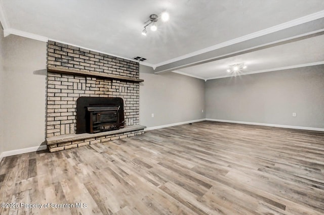 unfurnished living room with hardwood / wood-style flooring, crown molding, and a brick fireplace