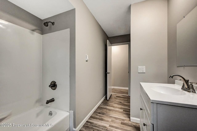 bathroom featuring washtub / shower combination, hardwood / wood-style floors, and vanity