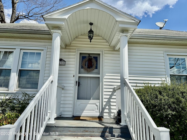 property entrance featuring a shingled roof
