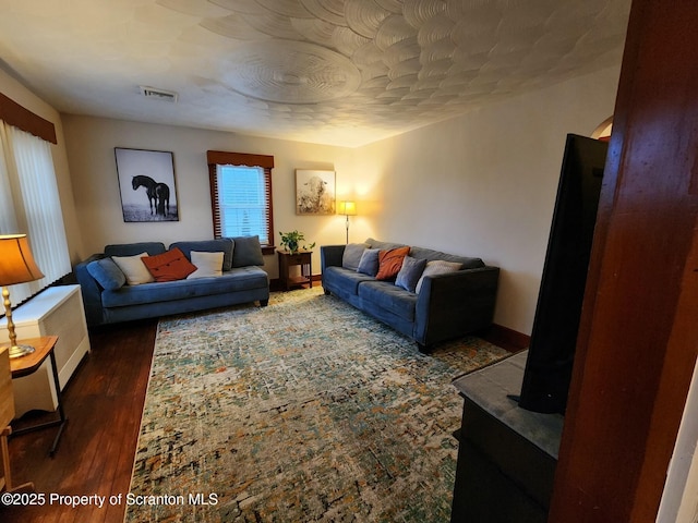 living area featuring visible vents and wood finished floors